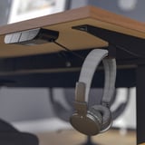 Headphones on desk hook under table.