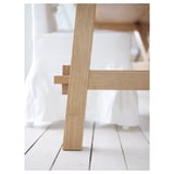 A close-up of a stylish wooden tables sturdy leg, showcasing its high-quality oak finish and natural grain pattern.
