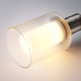 A close-up of a ribbed glass lampshade glowing warmly, showing detailed patterns, highlighting quality design.
