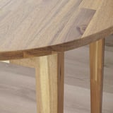 Wooden table close-up, showing smooth edge detail, natural grain patterns, and sturdy support structure.