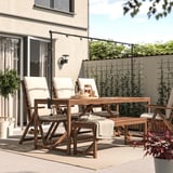 Backyard patio with dark wood NÄMMARÖ dining set and hanging lights. Comfortable for outdoor meals and relaxation.