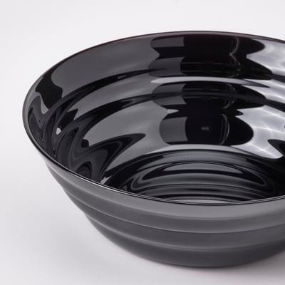 Black, round, glass bowl with a glossy, wavy design.