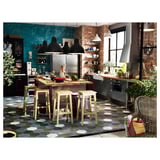 Modern kitchen with teal wall, wooden counter, and four black NILSOLLE barstools with metal footrests.