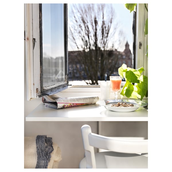 Window side table with items. Plant, chair, winter view.