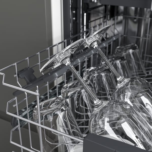 Open dishwasher: silverware top, glasses bottom, organized.