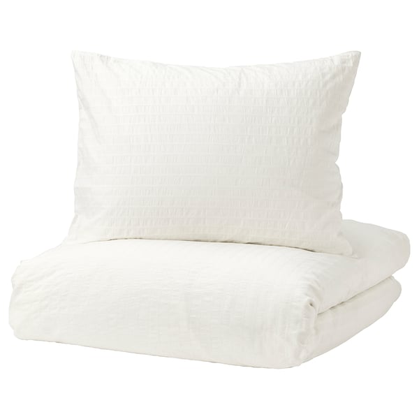 OFELIA VASS white cotton duvet set with crinkled texture. Square pillow in front, folded cover behind.