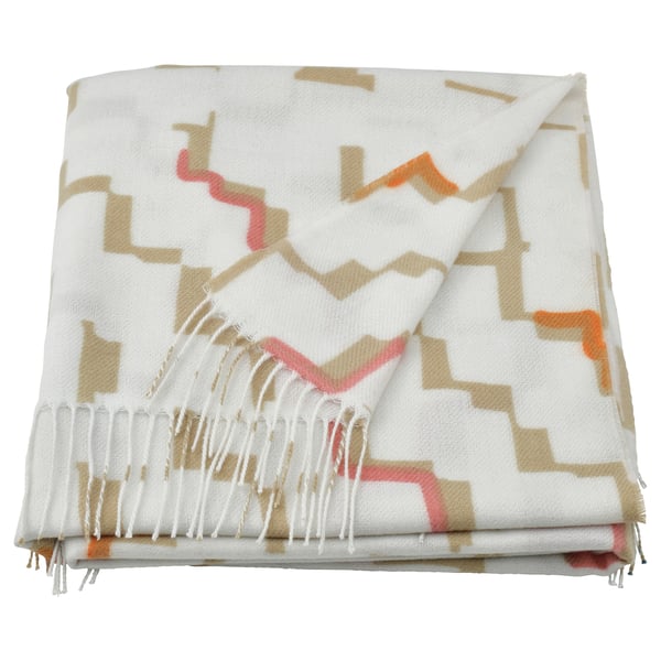 Folded OLIVSPINNMAL throw blanket in off-white with orange, brown, and grey geometric patterns, tasseled edges. Made from recycled polyester.