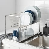 Stainless-steel dish drainer holds plates, bowls, and glasses, fitting up to 29 plates.