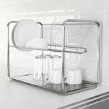 Stainless steel dish drainer on a counter, holding plates, bowls, and glasses.