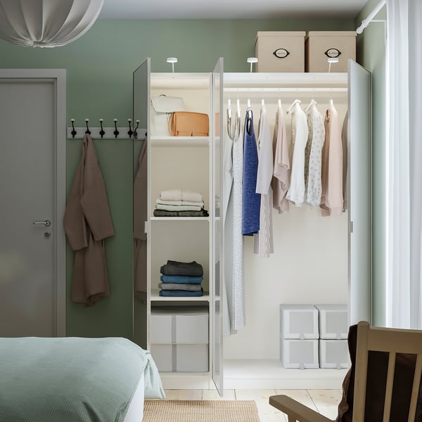 PAX wardrobe with mirrored doors, open showcasing clothes and storage.