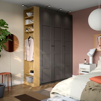 Modern bedroom with tall PAX wardrobe, sleek dark finish. Bed complementing decor.