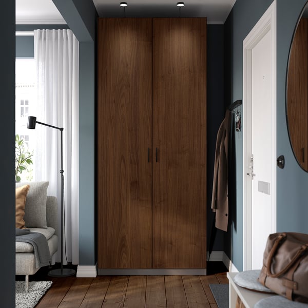 Modern bedroom with brown PAX wardrobe and cozy seating area.