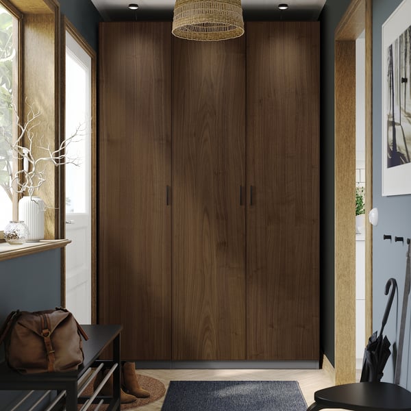 Wooden PAX wardrobe, tall with natural grain, offers ample storage.
