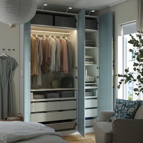 Bedroom wardrobe with clothes hangers, drawers, shelves, and integrated lighting.