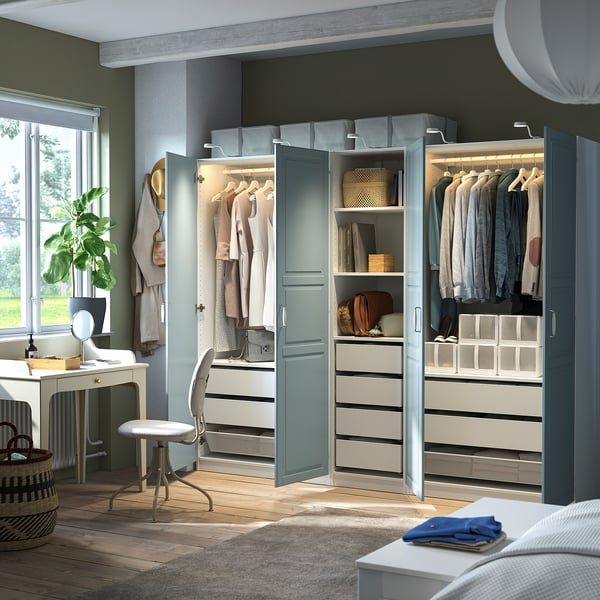 Modern bedroom with PAX wardrobe, open doors showing clothes and storage, integrated lighting.