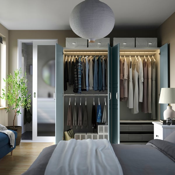 Modern bedroom with PAX wardrobe and lamp.