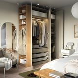 Bedroom with large wardrobe, hanging clothes, shelves, drawers, and built-in lighting.