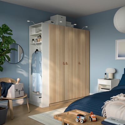 Modern kids bedroom with wardrobe, blue bed, toy train, plant.