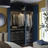 Modern bedroom with blue PAX wardrobe showing hangers, drawers, and interior organizers.