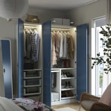 Blue wardrobe, open, reveals organized clothing. Hangable storage, shelves, led light, and shoe racks visible.