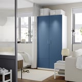 Modern blue PAX wardrobe between window and bed, reaching near ceiling