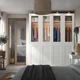 Modern bedroom with PAX wardrobe and glass doors.