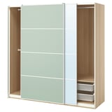 Modern PAX wardrobe with light green sliding doors, light wood interiors, and black mesh baskets.