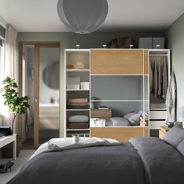 PAX wardrobe with sliding doors, shelves, and mirror. Adjustable feet and soft-close mechanism.