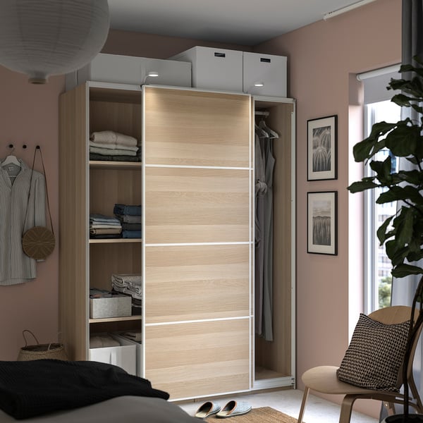 Modern light-colored wooden wardrobe with sliding doors, including shelves and storage boxes.