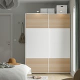 Minimalist bedroom with PAX wardrobe in white and light wood.