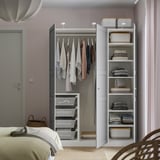 Open wardrobe displaying clothes on hangers and shelves with folded clothes, demonstrating organized storage solution.