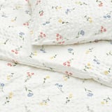 Floral duvet set with seersucker texture, elegant blooms, soft cotton blend, fine sheen, envelope closure pillowcase.