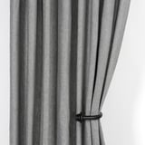 Black striped curtains held open by wooden tie-backs, showcasing their functional and decorative design.