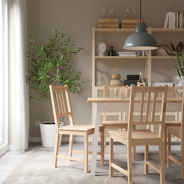 Cozy dining nook with PINNTORP chair, wooden table, plant, bookshelf, lamp.