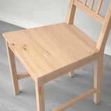 Light wooden chair with vertical slats. Crafted with visible wood grain, it exudes warmth and classic style.