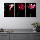 Three colorful PJÄTTERYD floral art pieces and decorative items on a gray console.