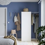Modern blue bedroom with PLATSA wardrobe, clothes, decorations, chair, plant.