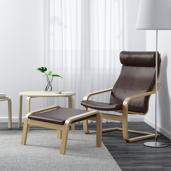 Modern living room with brown POÄNG recliner, footstool, and large window. This version includes the main elements and implies the cozy ambiance.