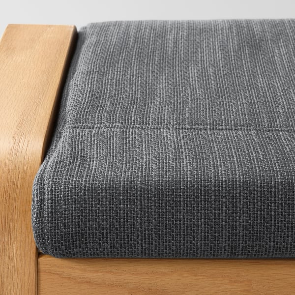Close-up of POÄNG footstool: durable grey fabric on sturdy wooden base.