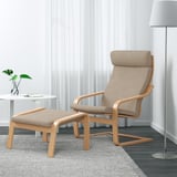 Minimalist living room: light brown POÄNG chair & ottoman, matching fabric, modern wooden frame, cozy & comfy, floor lamp, & plants.