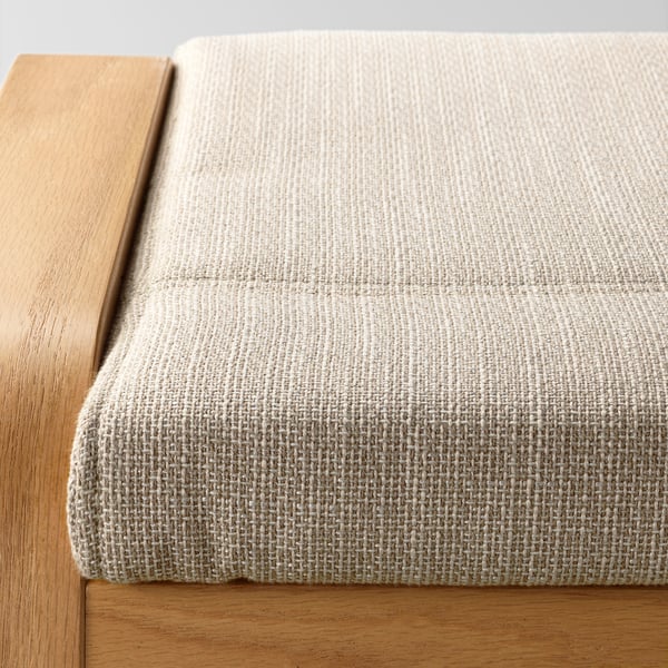 Close-up of a plush, textured cushion with wooden frame, showcasing soft, beige fabric.