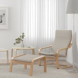 Minimalist living room: POÄNG chair, footstool, lamp, plant, curtains.