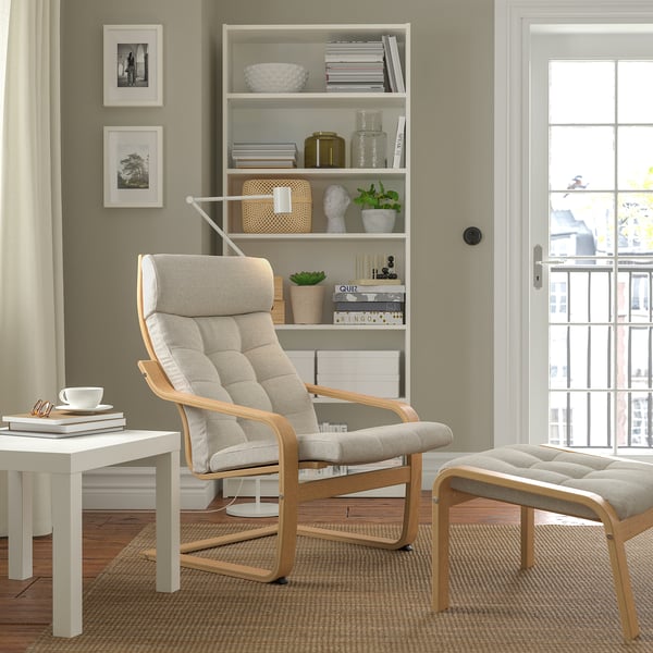 Modern living room with POÄNG chair, bookshelf, side table, and large window.