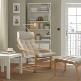 Modern living room with POÄNG chair, bookshelf, side table, and large window.