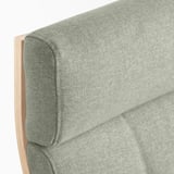Close-up of upholstered chair edge, light green fabric on wooden frame.