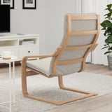 A modern armchair with a wooden frame and grey cushion, designed for comfort and support, positioned in a living room setting.