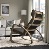 Modern rocking chair with high back and cushioned seat, perfect for relaxing by a window with natural light and views.