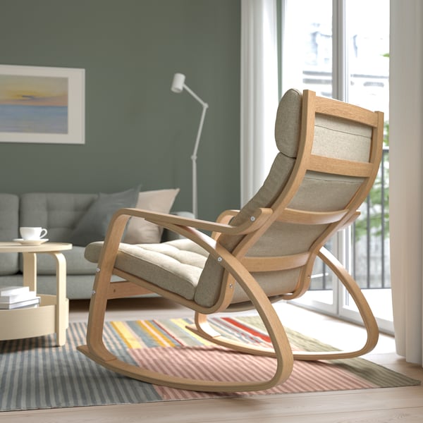 Modern rocking chair, upholstered seat & back, wooden frame, placed near window.