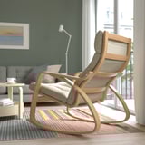 Modern rocking chair, upholstered seat & back, wooden frame, placed near window.