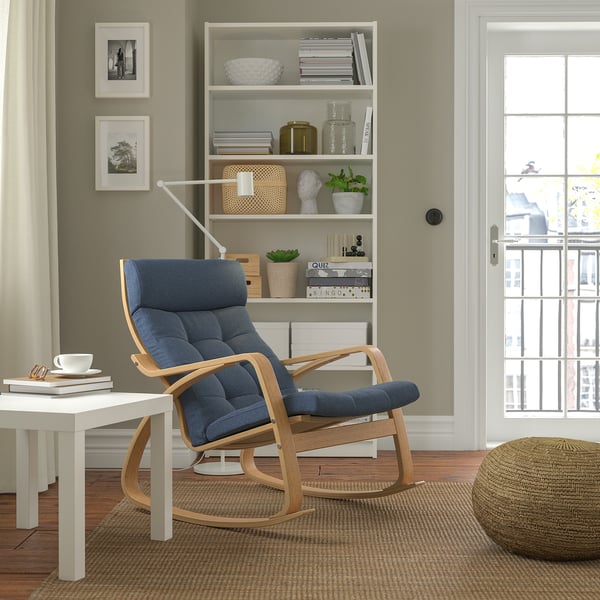 This image a stylish blue POÄNG rocking chair, made of oak veneer and soft poly-blend cushions, perfectly situated in a cozy living space.